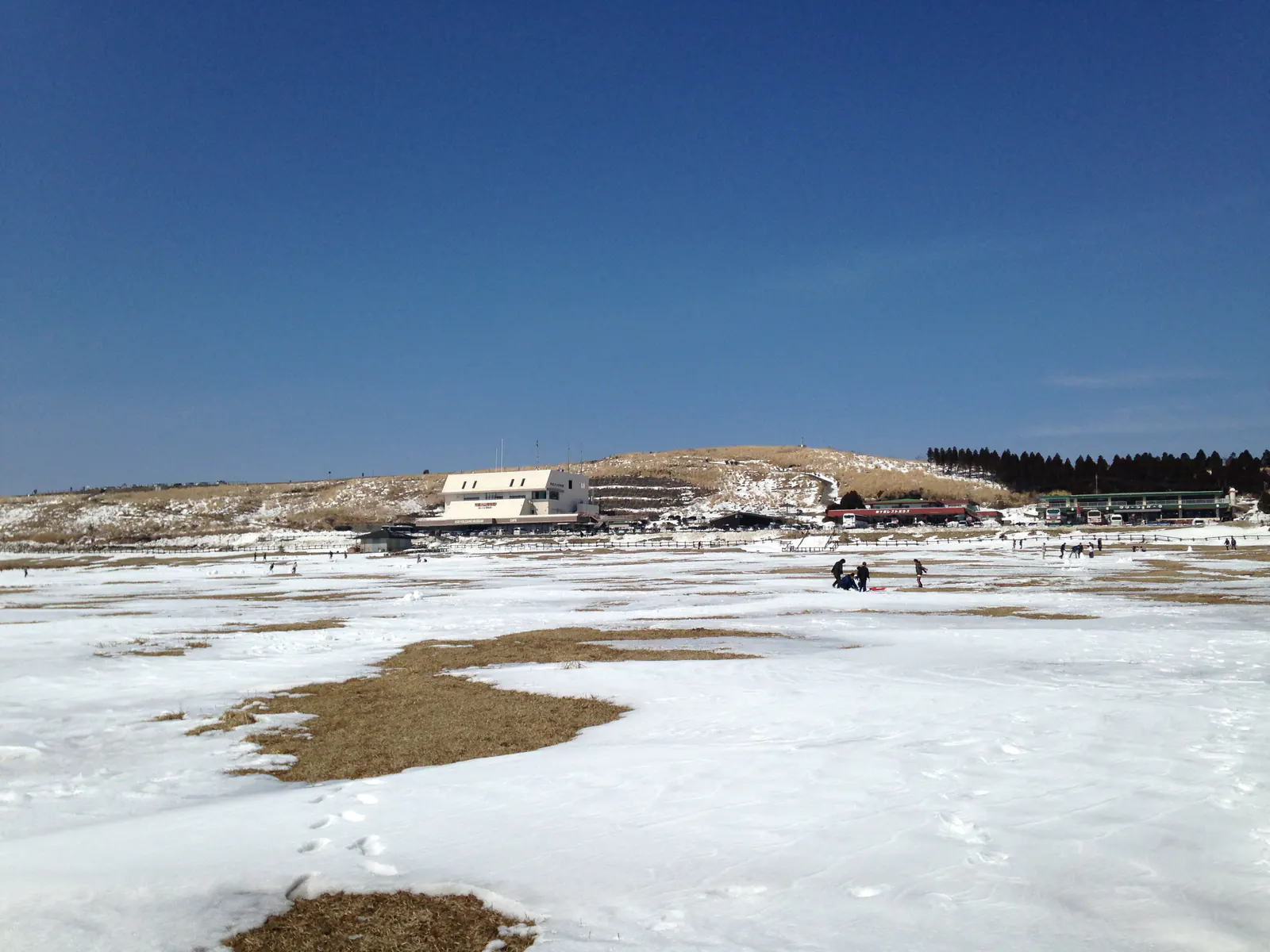雪に包まれた草千里ヶ浜と阿蘇の山並み
