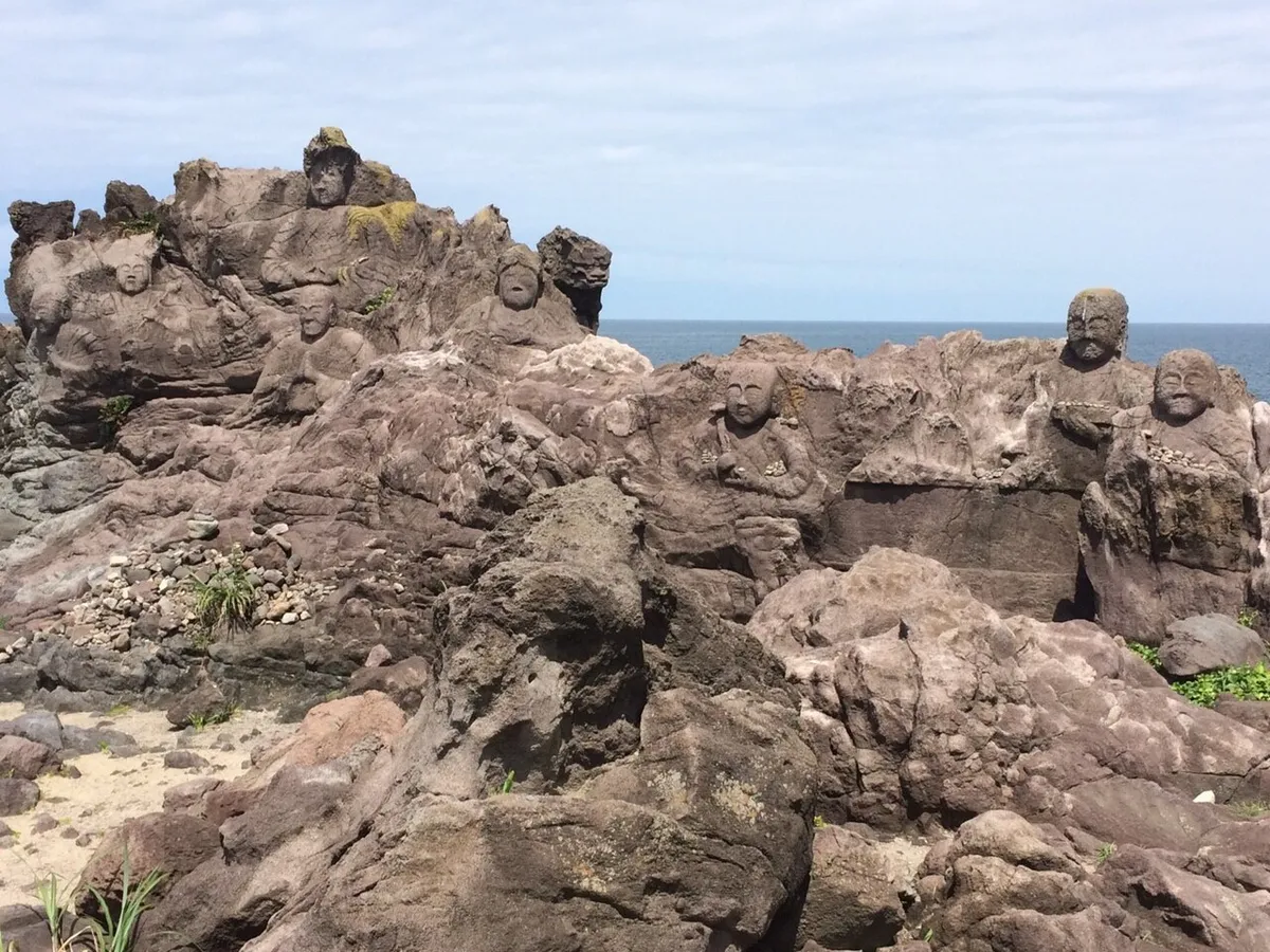 十六羅漢岩に刻まれた石仏と海辺の岩場