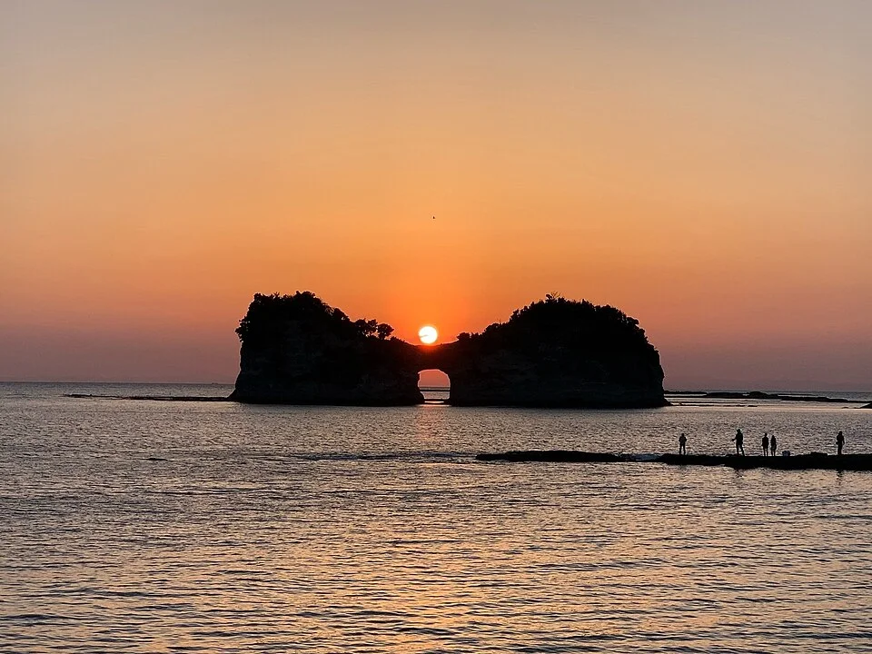 白浜の海に浮かぶ、中央に穴のある円月島