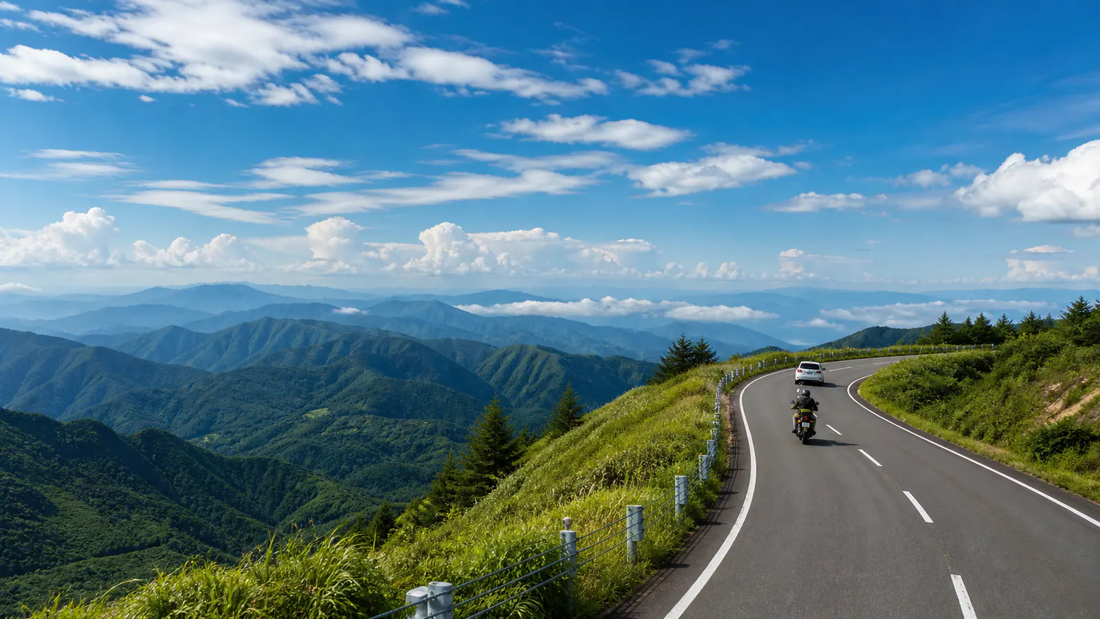 高原の道を安全な間隔で走る車とバイク
